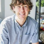Ian Redfield, therapist at Renewed Stories Counseling, with curly hair in a blue checkered shirt, providing compassionate mental health support in Spokane