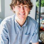Ian Redfield, therapist at Renewed Stories Counseling, with curly hair in a blue checkered shirt, providing compassionate mental health support in Spokane
