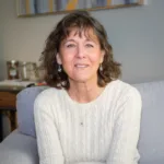 Janeen Leachman, Clinical Mental Health Counseling graduate student at Renewed Stories Counseling, smiling warmly while seated in a welcoming therapy office, providing compassionate counseling for individuals of all ages in Spokane