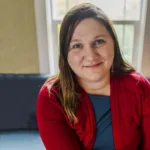 Jessica Kaluza, therapist at Renewed Stories Counseling, with dark hair in a red cardigan over blue top, offering supportive family and couples therapy in Spokane