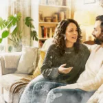 Watercolor illustration of a couple talking warmly on a couch, representing couples therapy in Spokane at Renewed Stories Counseling Watercolor illustration of a couple talking warmly on a couch, representing couples therapy in Spokane at Renewed Stories Counseling