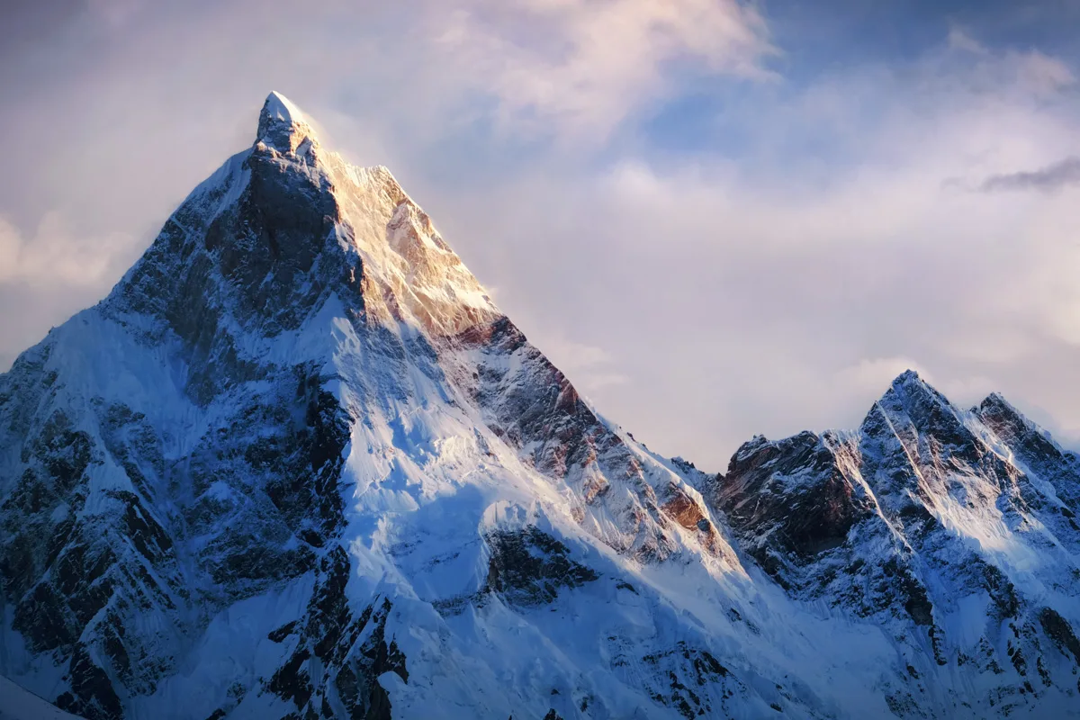 Majestic snow-covered mountain peak bathed in golden sunlight against a dramatic cloudy sky, representing the challenging but rewarding journey of rebuilding relationships
